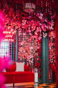 Habitación con sofá rojo y flores en la pared en Virgin Hotels New Orleans en Nueva Orleans