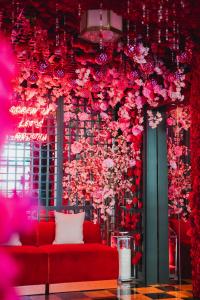 une chambre avec un canapé rouge et des fleurs sur un mur dans l'établissement Virgin Hotels New Orleans, à La Nouvelle-Orléans