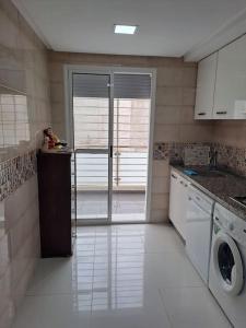 eine Küche mit Waschmaschine und Trockner in der Unterkunft Apartamento moderno Aparcamiento gratis in Tétouan