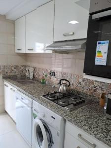 eine Küche mit einem Herd und einer Waschmaschine in der Unterkunft Apartamento moderno Aparcamiento gratis in Tétouan