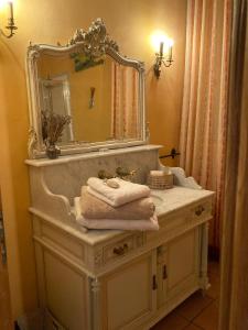uma casa de banho com lavatório, espelho e toalhas em Manoir du Bouyssou em Cintegabelle