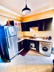 a kitchen with a stainless steel refrigerator and a dishwasher at Appartement luxueux Centre Agadir in Agadir