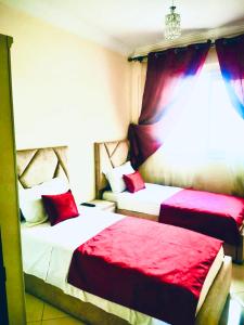 two beds in a room with red and white at Appartement luxueux Centre Agadir in Agadir