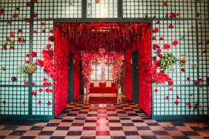 ニューオーリンズにあるVirgin Hotels New Orleansの赤い花と赤いソファが飾られた部屋