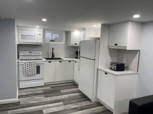 una cucina bianca con elettrodomestici bianchi e pavimenti in legno di Apartment in St Thomas a Saint Thomas
