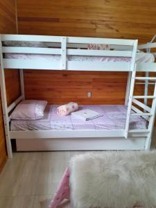 a white bunk bed with a doll laying on it at casa dos sonhos in Bom Jardim da Serra