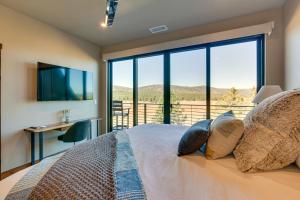 a bedroom with a bed with a large window at Angel Fire Home with Hot Tub Less Than 1 Mi to Ski Slopes! in Angel Fire
