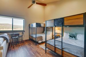 two bunk beds in a room with a table and a window at Angel Fire Home with Hot Tub Less Than 1 Mi to Ski Slopes! in Angel Fire