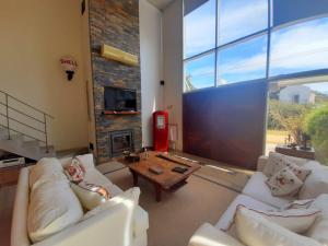 a living room with white couches and a fireplace at AQUI NO ES in Punta del Este