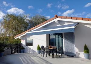 a blue awning on a patio with a table at Los Sauces de la Fuente in Santillana del Mar