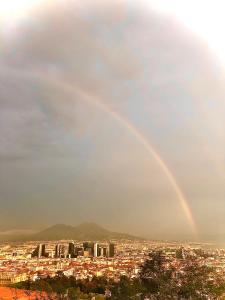 um arco-íris no céu sobre uma cidade em Nanà Home em Nápoles