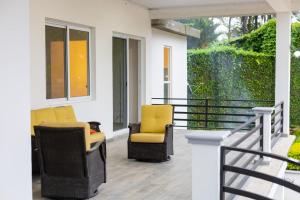 a porch with two yellow chairs on a house at Hotel, Cocoview Valle de angeles in Valle de Ángeles