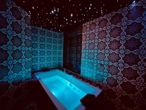 eine Badewanne in einem Zimmer mit einer Wand in der Unterkunft Chambre & spa "La Casa Blue" ZALIPIE in Wingles