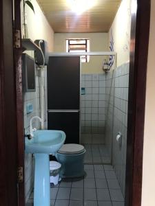 uma casa de banho com um WC azul e um lavatório. em Linda casa com exc. localização em Castanhal