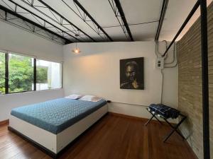 a bedroom with a bed and a painting on the wall at Espacioso apartamento con jacuzzi en el Poblado in Medellín