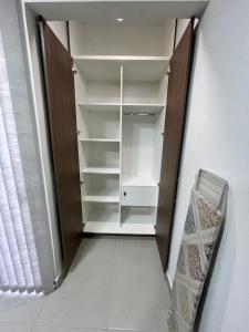 a walk in closet with white shelves and a window at Amplio departamento a estrenar en Asunción, excelente ubicación in Asuncion
