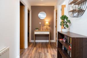 pasillo con escritorio y mesa con espejo en Cosy Modern City Centre 2 Bed Apartment, en Belfast
