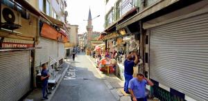 a group of people walking down a street with shops at Menesa Hotel in Istanbul