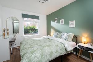 a bedroom with a bed and a desk and a window at City Vibe Haven - Modern 2 Bed Apartment with High Speed WI-FI in Belfast