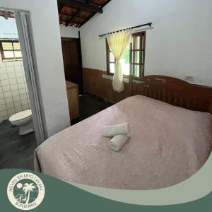ein Schlafzimmer mit einem Bett mit zwei Handtüchern darauf in der Unterkunft Hostel Recanto Caiçara in São Sebastião
