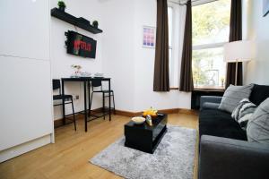 a living room with a couch and a table at Perfectly Located City Centre Apartment, Free Parking, Cable TV and WI-FI in Cardiff