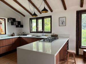 a kitchen with a white counter top and some windows at El Tambo Retreat in Machachi