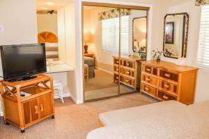 um quarto com uma televisão e um espelho em Berkshire on the Ocean (timeshare resort) em Delray Beach