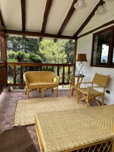 un porche cubierto con sillas y mesa en El Tambo Retreat, en Machachi