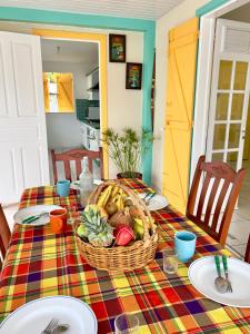 a table with a basket of fruit on a colorful table cloth at Villa KAZ A ZOT in Port-Louis