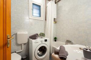 a bathroom with a washing machine and a sink at Rivercity South Buda Hills in Budapest