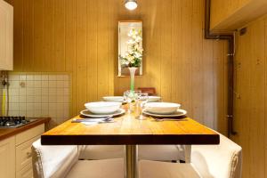 a kitchen with a wooden table with white bowls at Rivercity South Buda Hills in Budapest