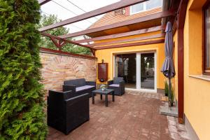 a patio with chairs and an umbrella on a brick patio at Rivercity South Buda Hills in Budapest