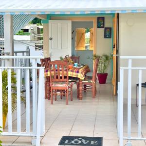 a porch with a table and chairs on it at Villa KAZ A ZOT in Port-Louis