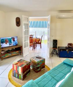 a living room with a couch and a tv at Villa KAZ A ZOT in Port-Louis