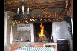 een keuken met een open haard, een tafel en een open haard bij Chalet en Miño con vistas al mar in Miño