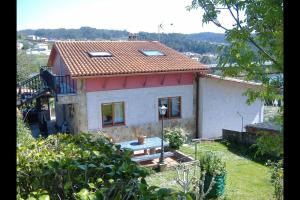 a small house with a red roof at Chalet en Miño con vistas al mar in Miño