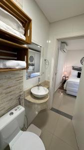 uma casa de banho com um WC, um lavatório e uma cama em Lindo e confortável apartamento no Centro de Foz em Foz do Iguaçu