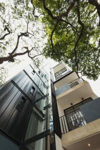 een hoog gebouw met glazen ramen en bomen bij Altio Hotel in Cali