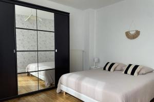 Un dormitorio con una cama y una puerta corrediza de vidrio. en Cocon lumineux, en Lorient