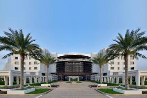 JW Marriott Hotel Muscat في مسقط: عماره امامها نخيل