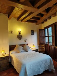 Un dormitorio con una cama grande en una habitación con techos de madera. en Complejo Rural Las Palomas, en Jerte