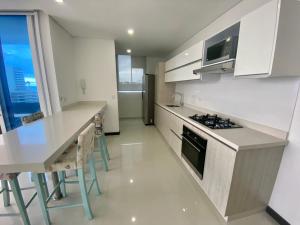 cocina con armarios blancos y encimera en Apartamentos Ocean Club - Cerca al Mar by SOHO, en Santa Marta