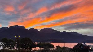 a sunset over the water with mountains in the background at Le Chalet de la Plage in Sévrier