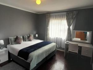 a bedroom with a large bed and a window at Step-by-Step Self-Catering and B&B in Bellville