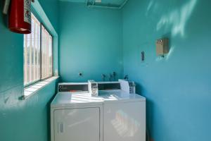 a blue laundry room with a washer and dryer at Airy Long Beach Condo Rental 2 Mi to Ocean! in Long Beach +17 photos