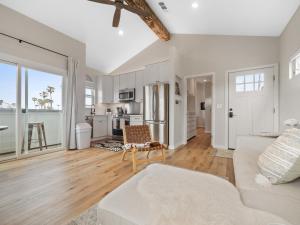 a living room with a white couch and a kitchen at A4609b- Sunset Cliffs Dream Apartment in San Diego