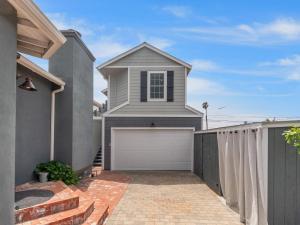 une maison avec un garage blanc et une clôture dans l'établissement A4609b- Sunset Cliffs Dream Apartment, à San Diego