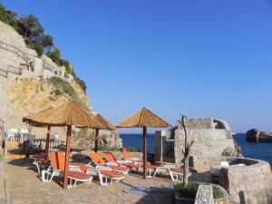 a group of chairs and umbrellas and the ocean at Apartments & Rooms Villa Anastasija in Ulcinj
