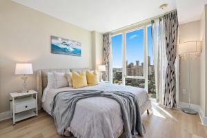 a bedroom with a bed and a large window at Allure Waikiki condo in Honolulu