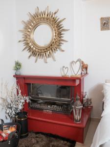 a living room with a fireplace and a mirror at Comfy and Cosy Studio Kalamata in Kalamata